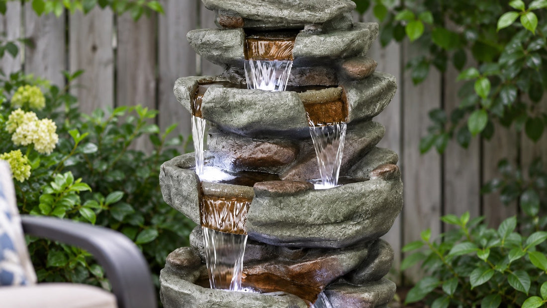 Close view of water dropping between stacked rock ledges on a garden waterfall fountain