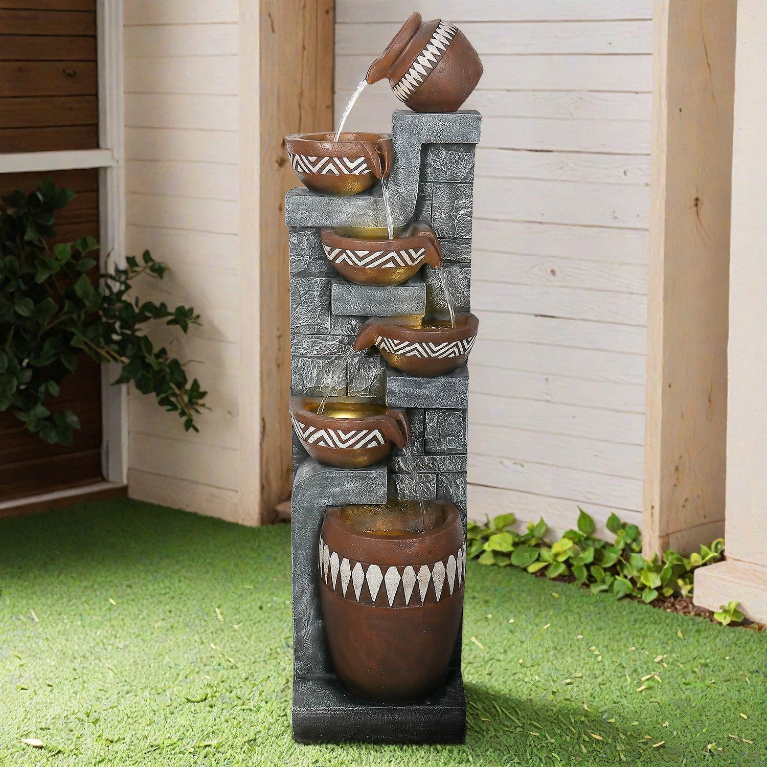 56.6" 6-tiered polyresin waterfall fountain acting as a centerpiece in a tropical garden