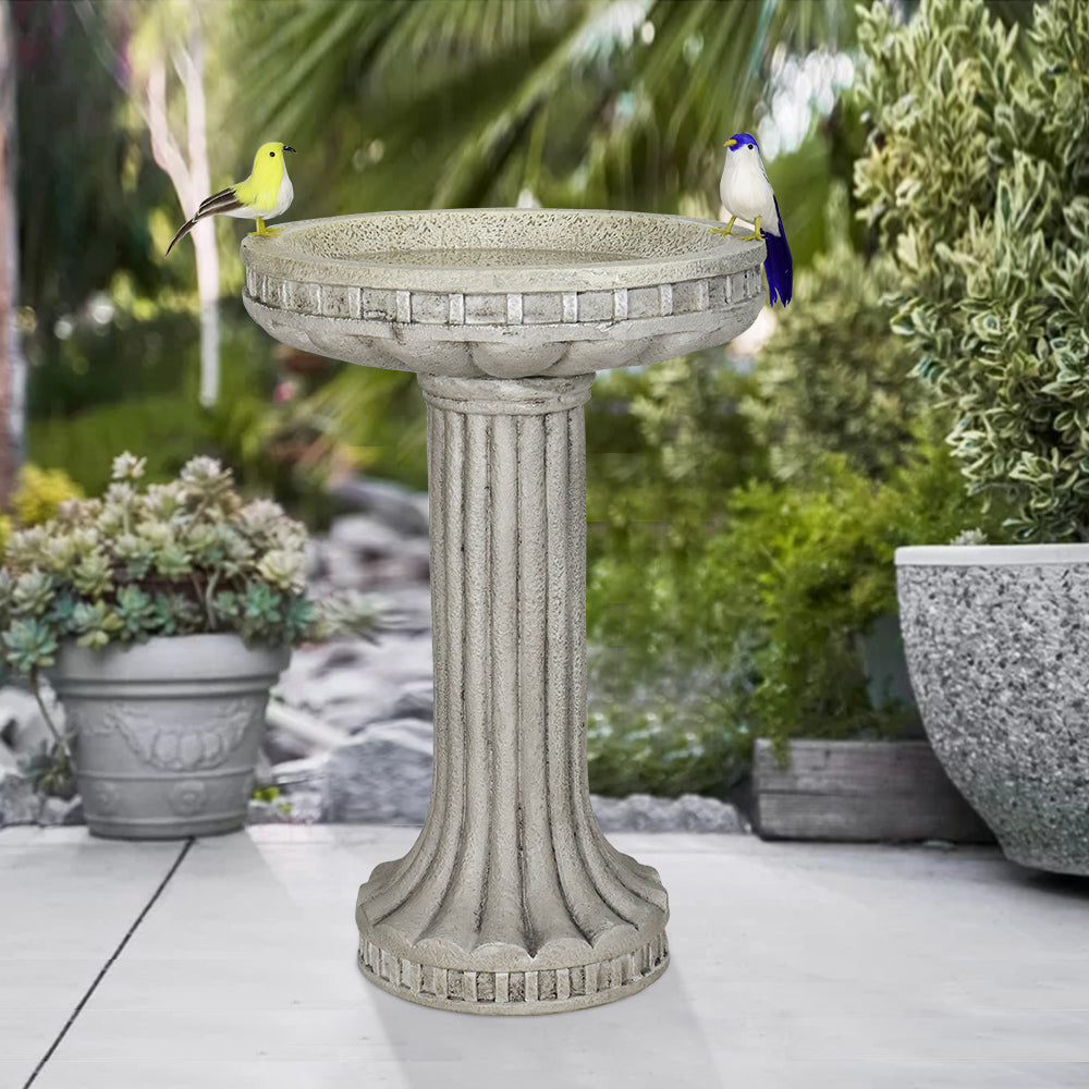 Compact round pedestal birdbath as a decorative focal point on a small patio