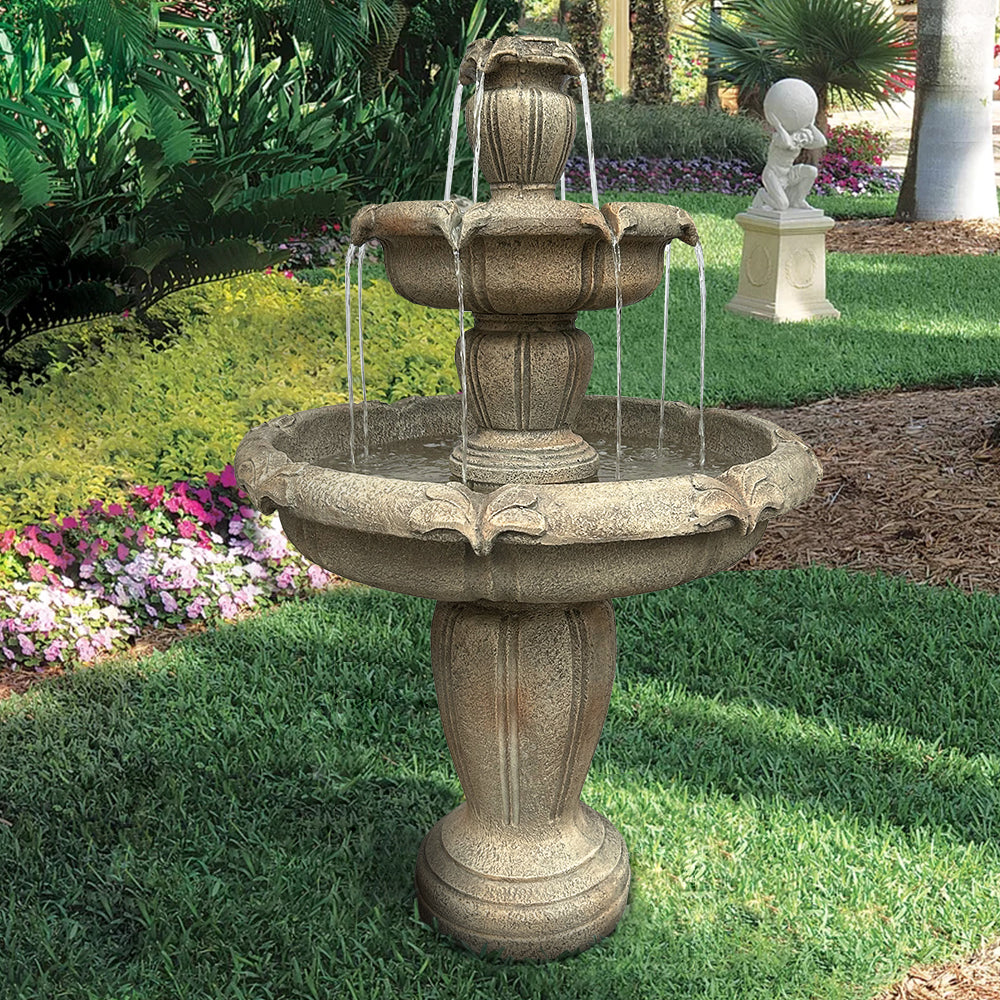 Eco-friendly 3-tier concrete floor fountain blending seamlessly with a backyard garden landscape.