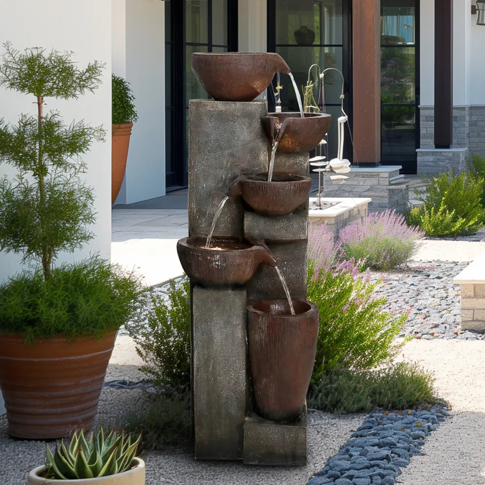 Five-level copper bowl fountain as a garden centerpiece, viewed from a distance in a landscaped yard.