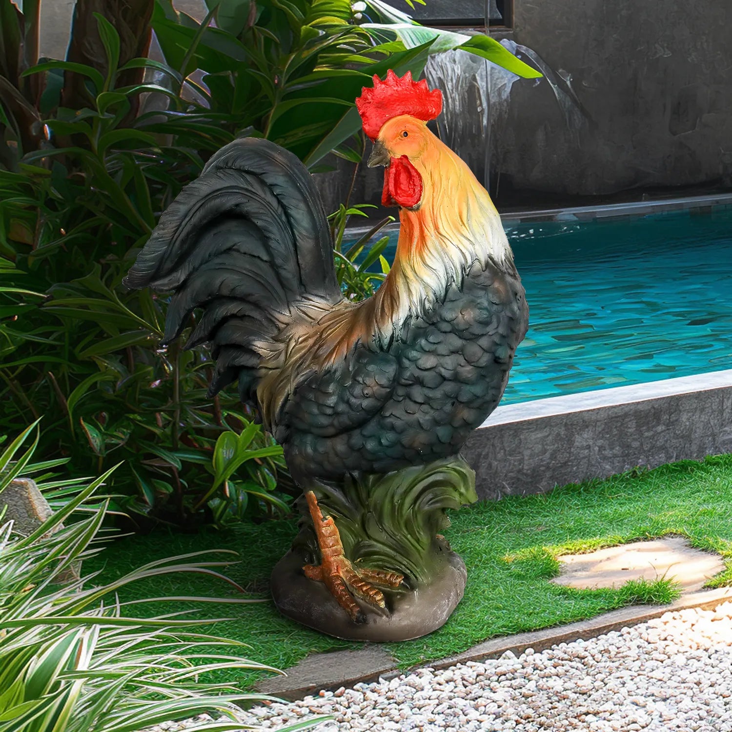 Hand-painted rooster garden statue placed in a lush green backyard with tropical plants.