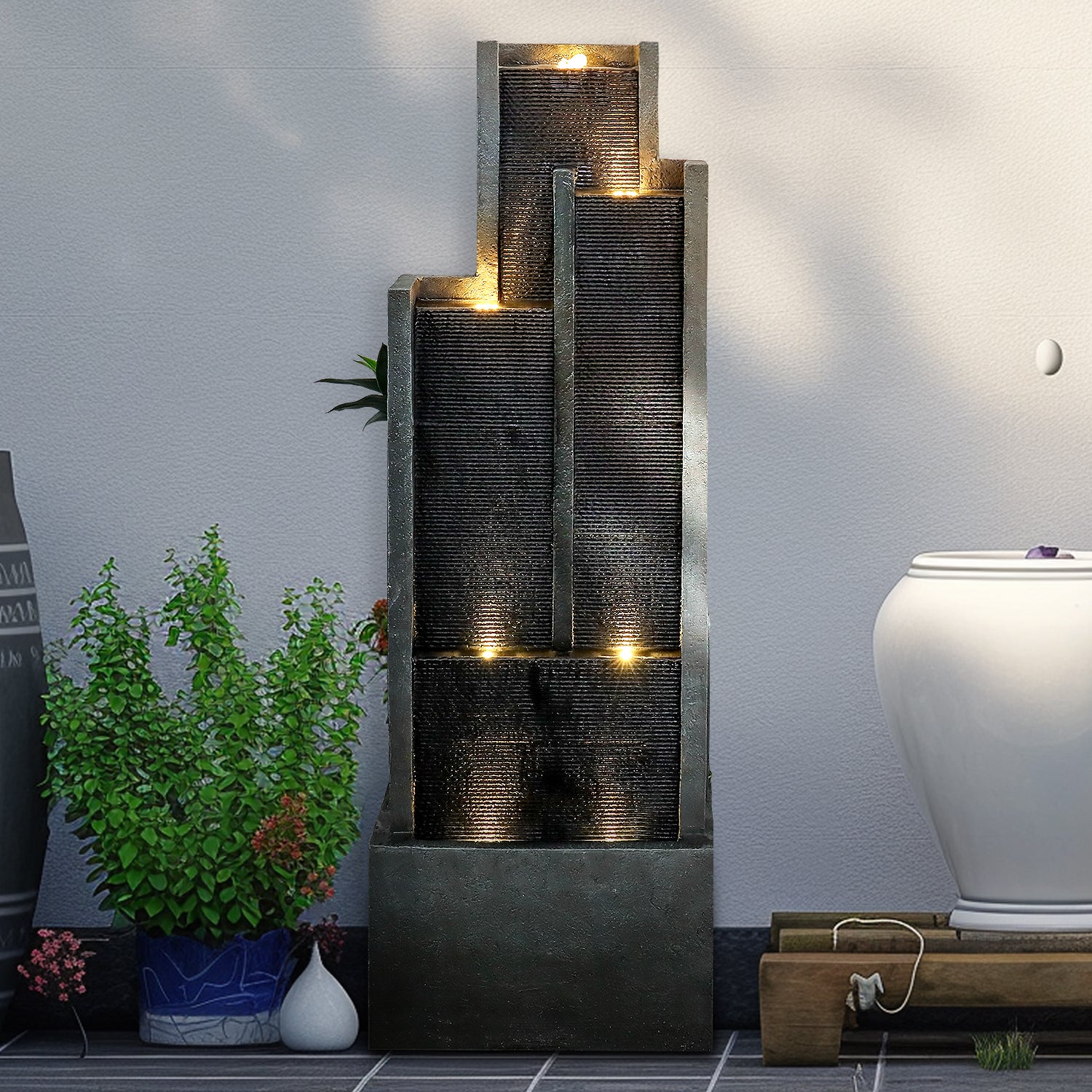 Sturdy 21kg modern black outdoor fountain creating a minimalist aesthetic against a house wall.