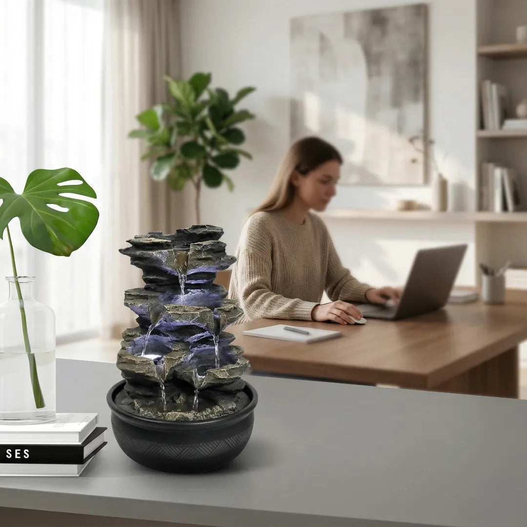 Tranquil tabletop fountain centerpiece on a minimalist office desk in daytime.