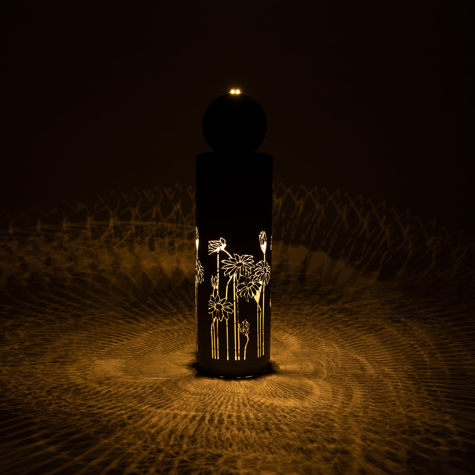 gilded vine cutout fountain glowing at night with illuminated pattern
