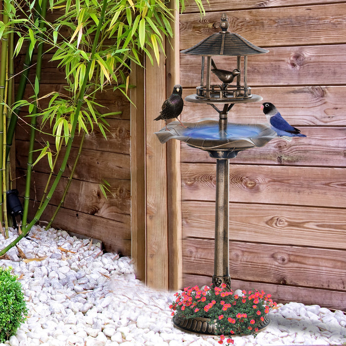 verdigris 3-in-1 bird bath with birds perched on basin and flowers planted in base bowl beside a wooden fence