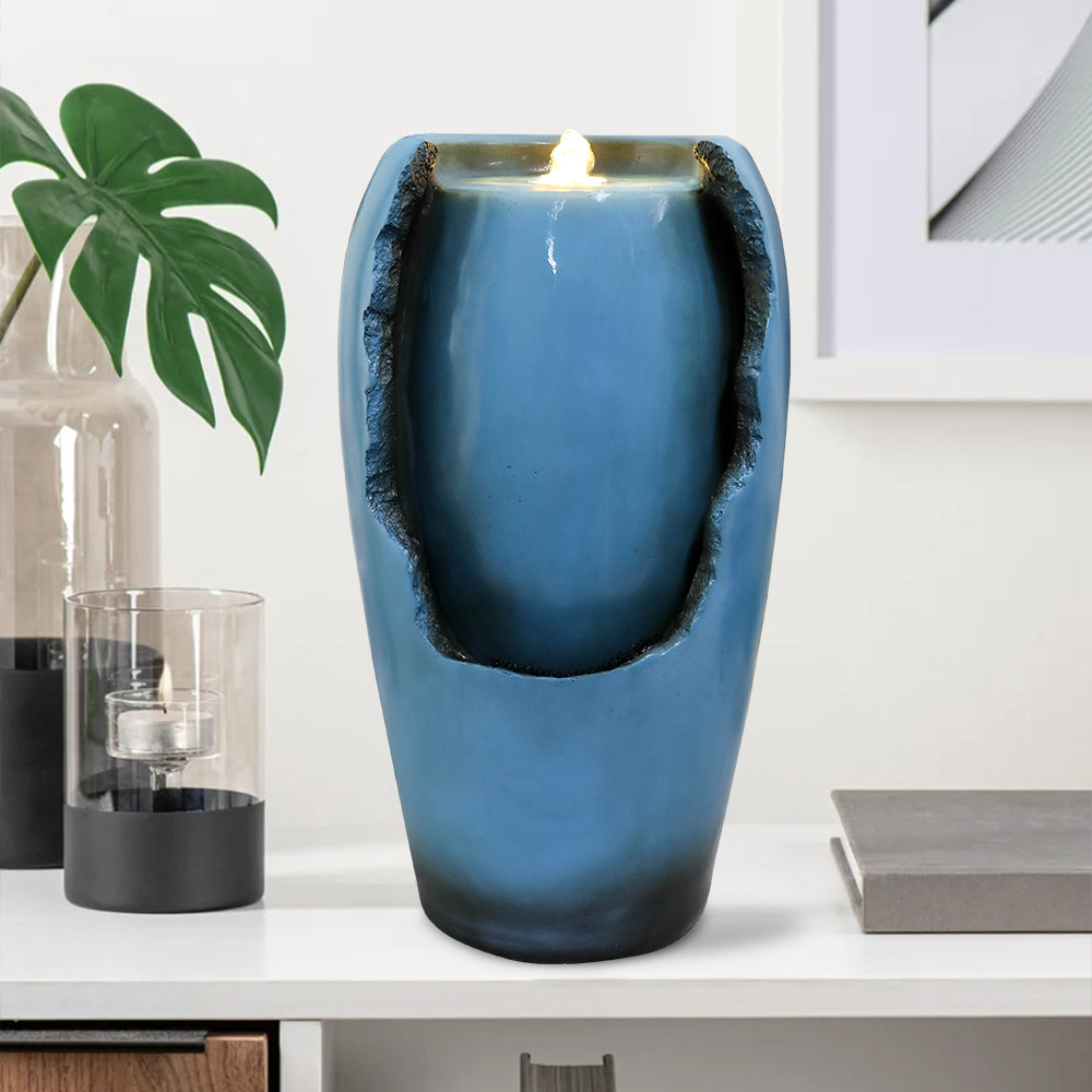 Blue vase indoor tabletop fountain displayed on a white living room console