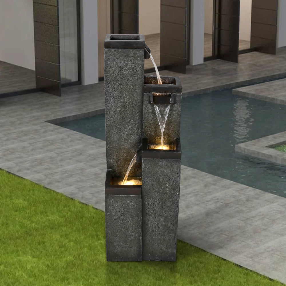 Cascading square pillar waterfall serving as a stylish centerpiece for a modern yard
