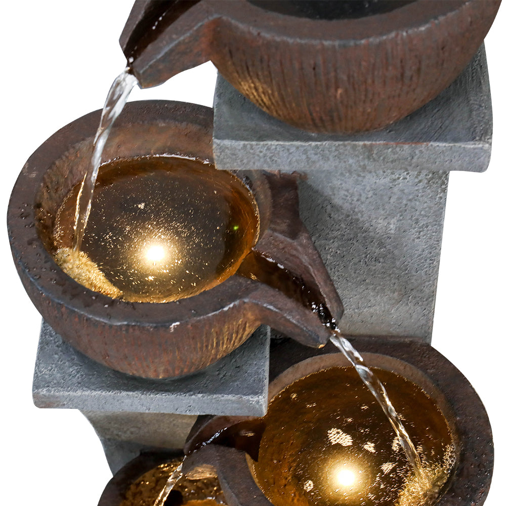 Close-up focusing on the secondary illuminated pot receiving cascading water flow.