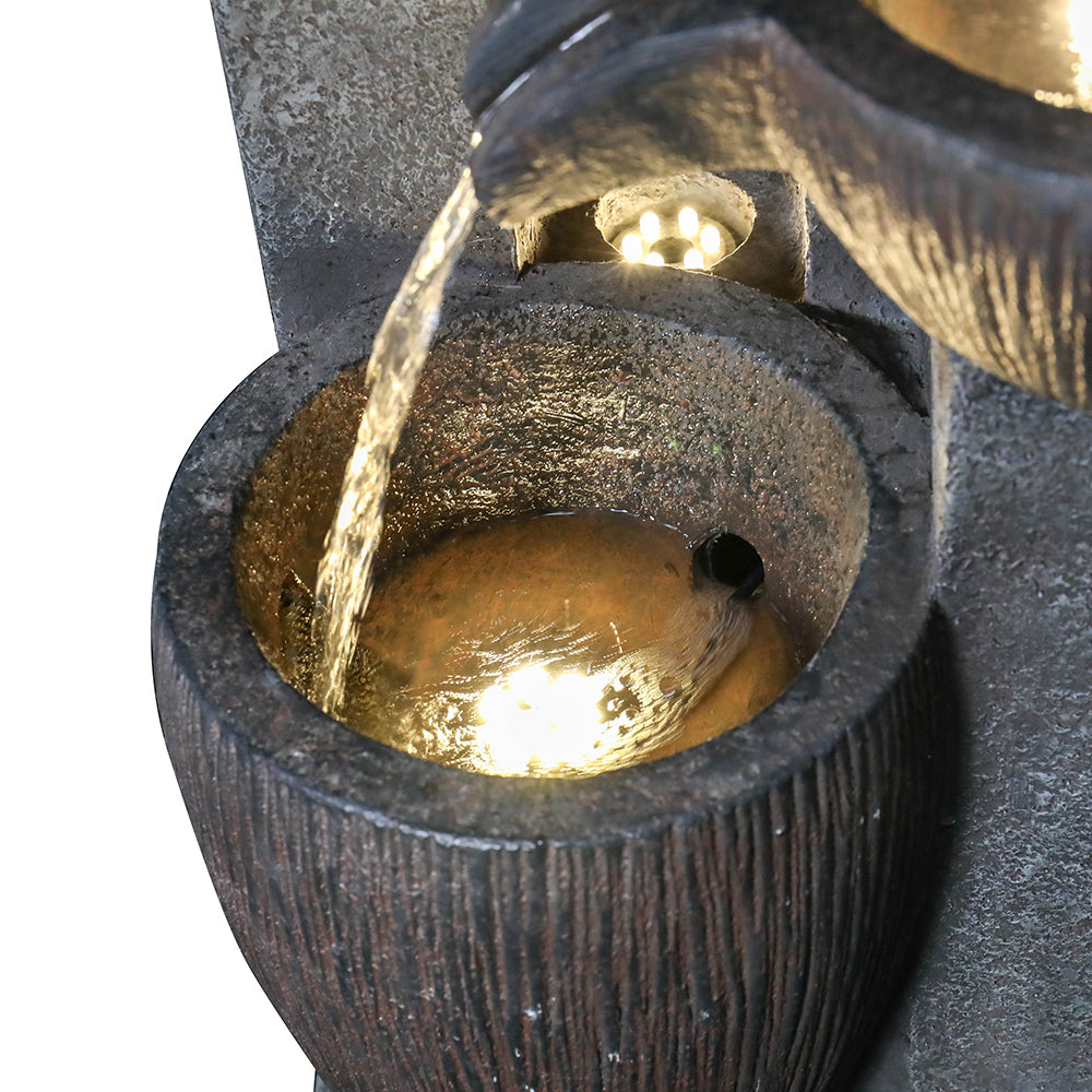 Close-up of the gentle water current flowing into the bottom basin of the pots fountain
