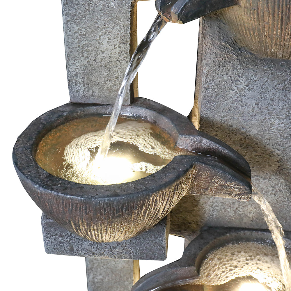 Detailed view of the cascading water trickling through the middle pots of the tiered fountain