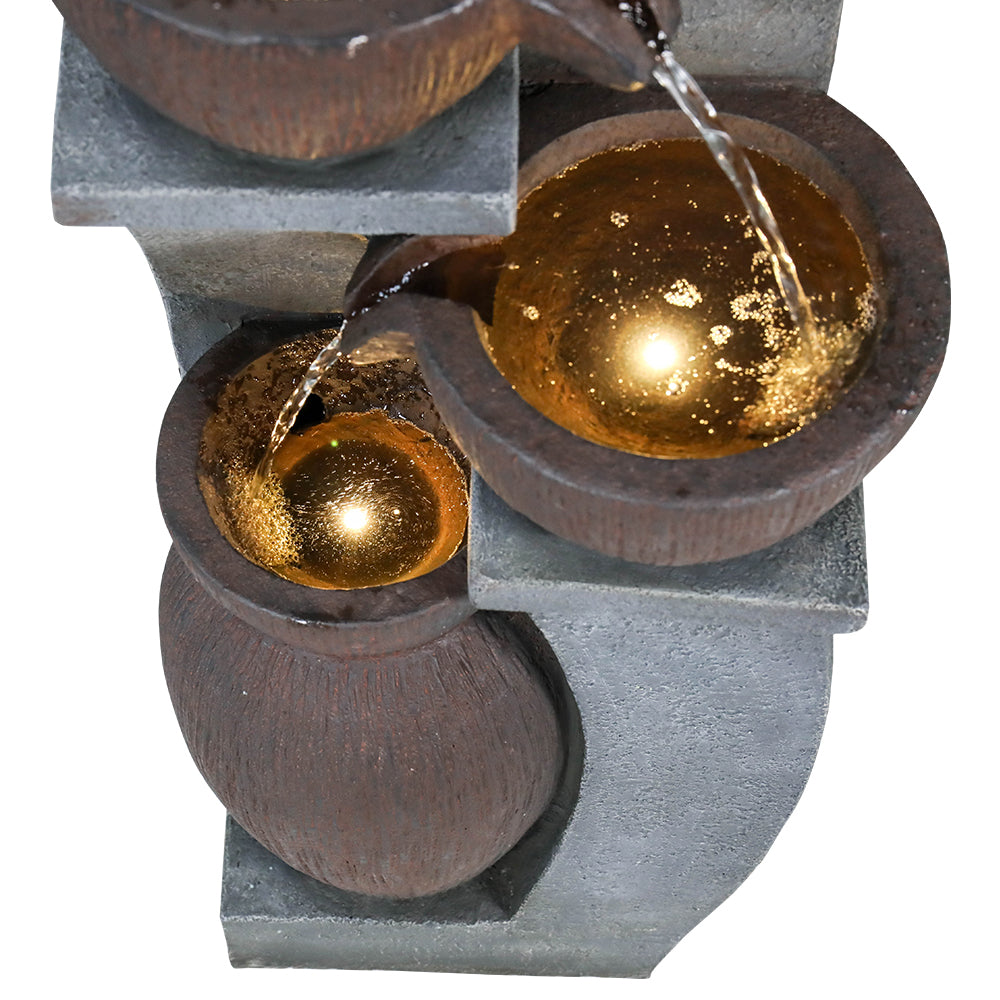 Macro view of water cascading into the illuminated bottom basin of the 4-tier fountain.