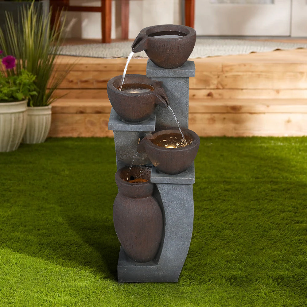 Modern resin freestanding fountain placed beautifully on a green grass lawn.