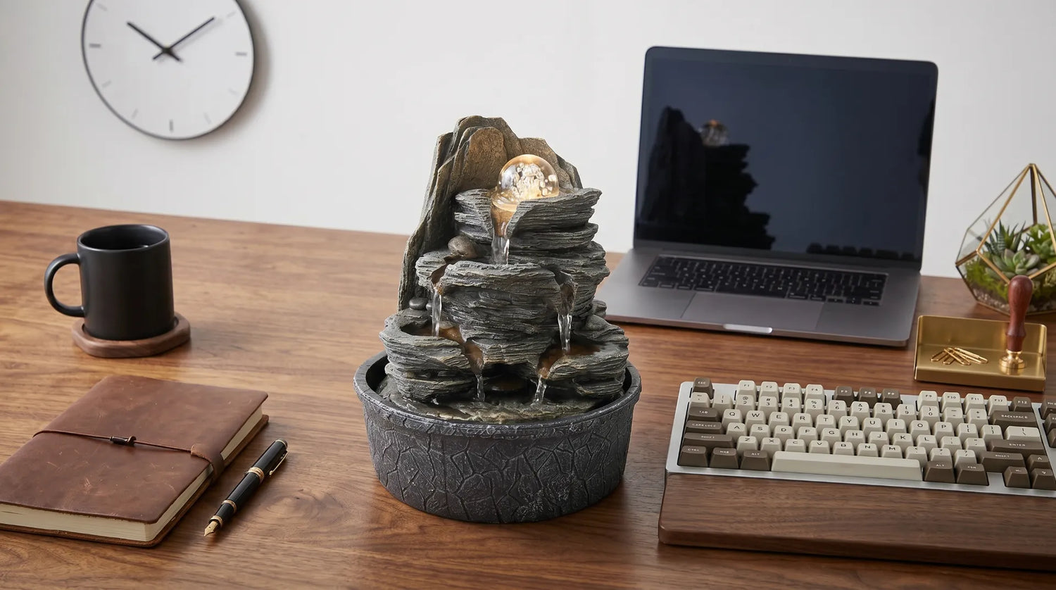 Polyresin indoor tabletop fountain safely placed on a wooden office desk next to a laptop