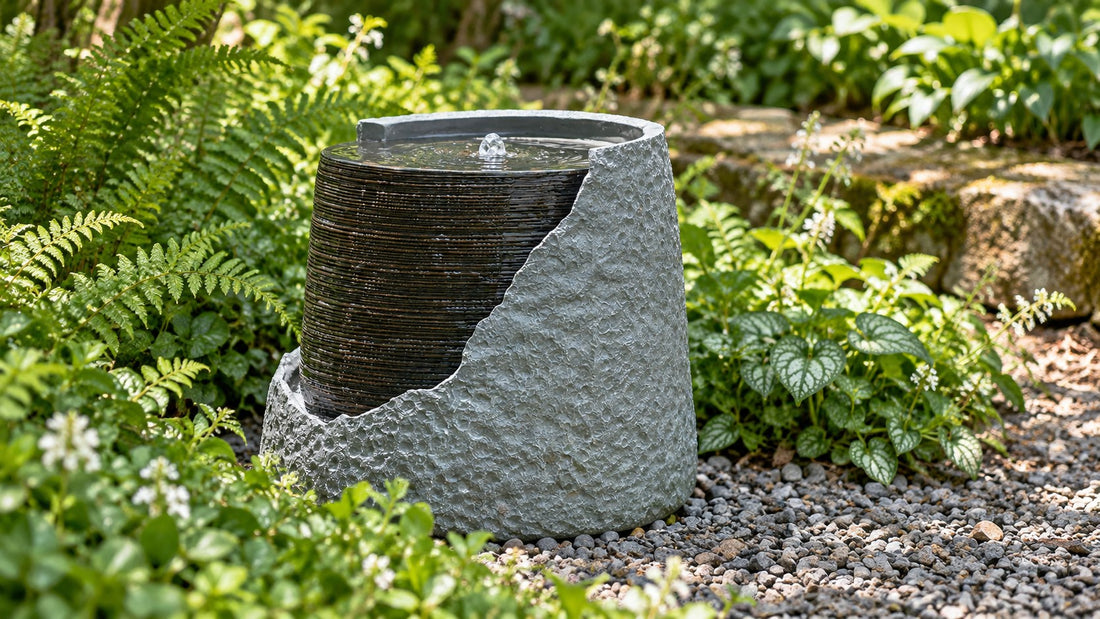 Urn fountain with the front face cut away showing water running down the ribbed inside, set among ferns