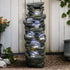 51-inch tall multi-tier rock cascading fountain against a white wooden garden fence.