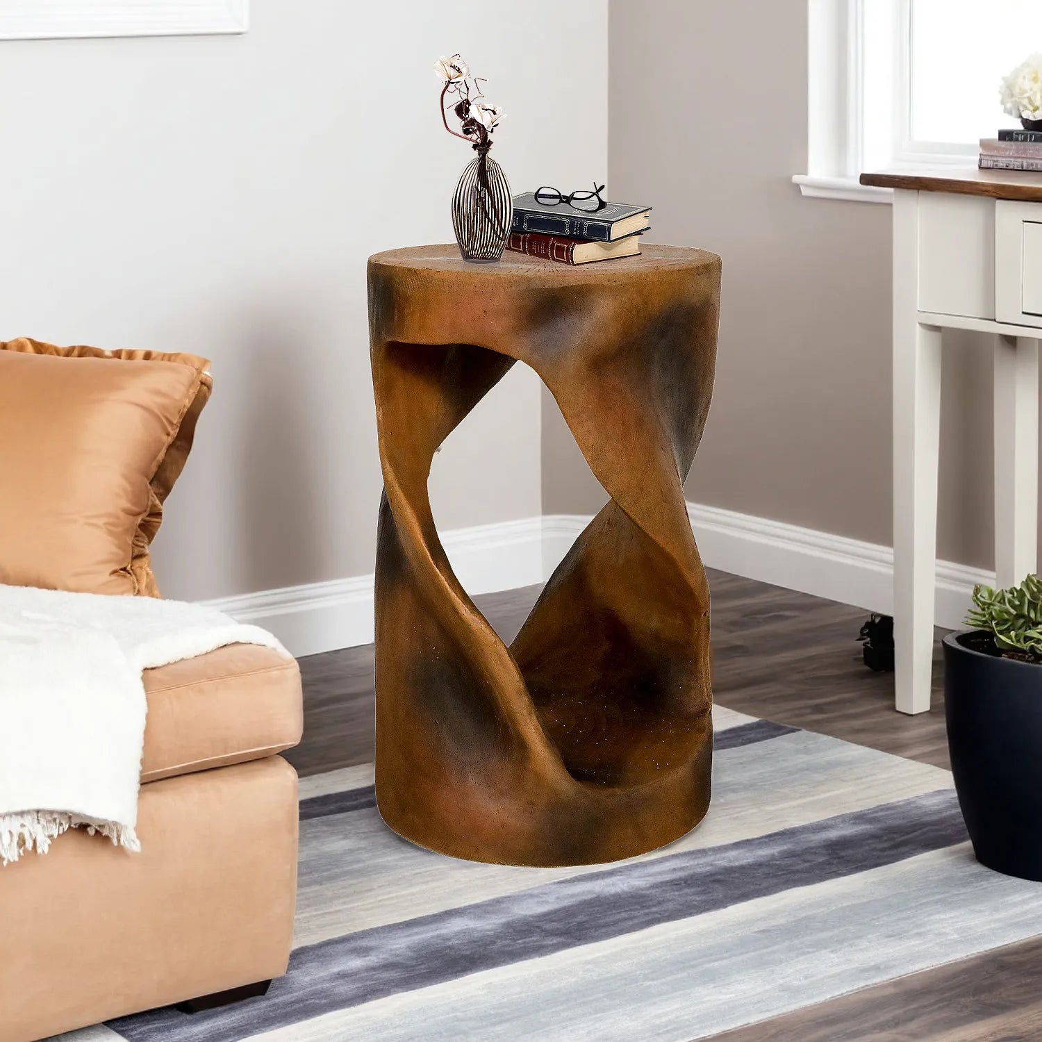 Artistic spiral side table with a wood-look finish next to a sofa on a blue rug.