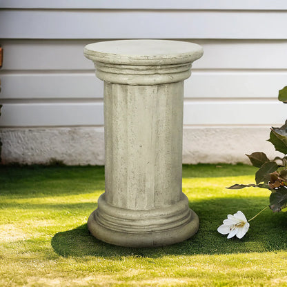 Classic 20-inch pedestal side table in faux stone finish on a lush green outdoor lawn.