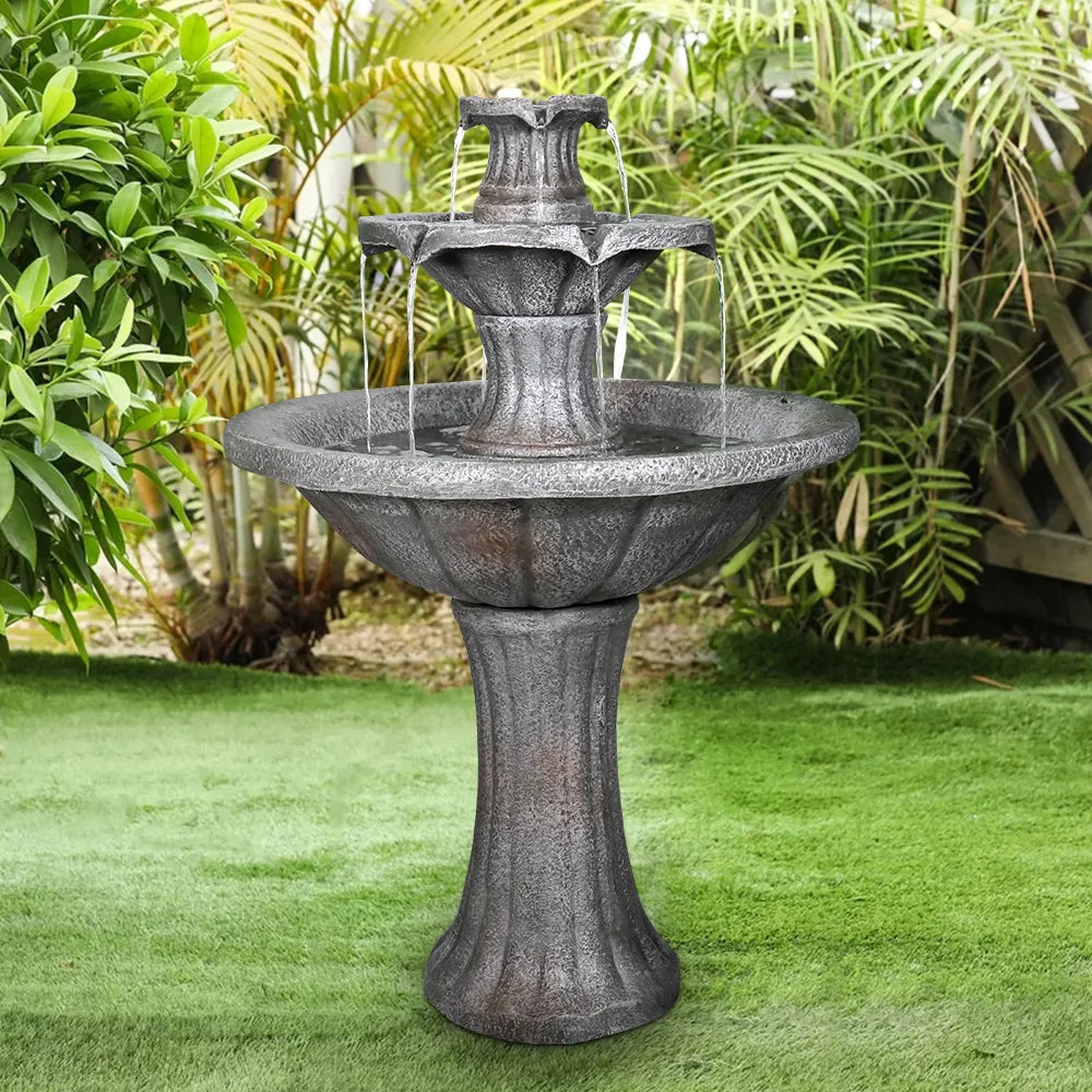 Classical 41.7-inch 2-tier marble finish concrete fountain in a lush green tropical garden setting.
