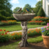 Classical goddess figurine concrete bird bath standing elegantly in a garden bed with colorful hydrangeas.
