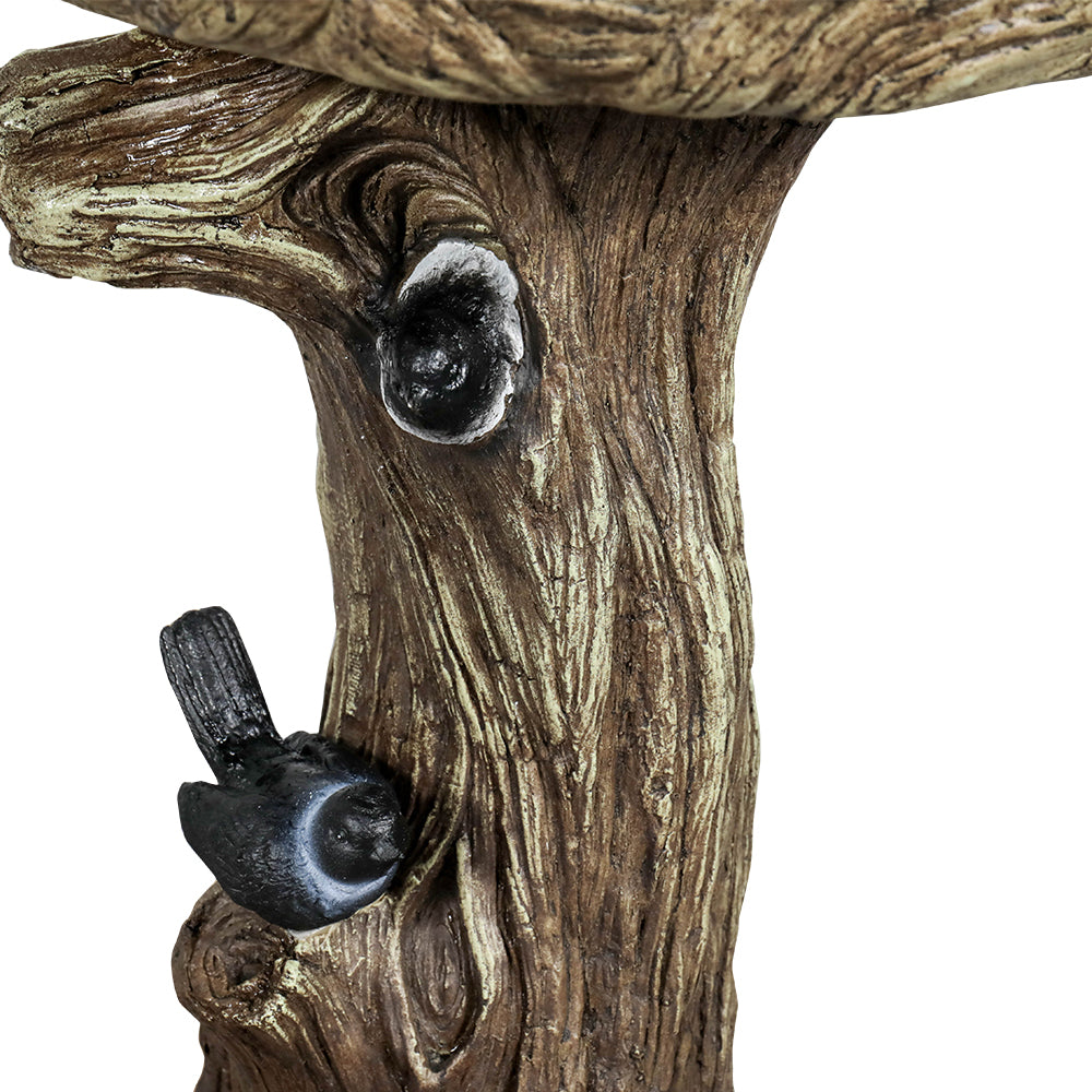 Close-up of Small Bird Statue Decoration on Bird Bath Rim