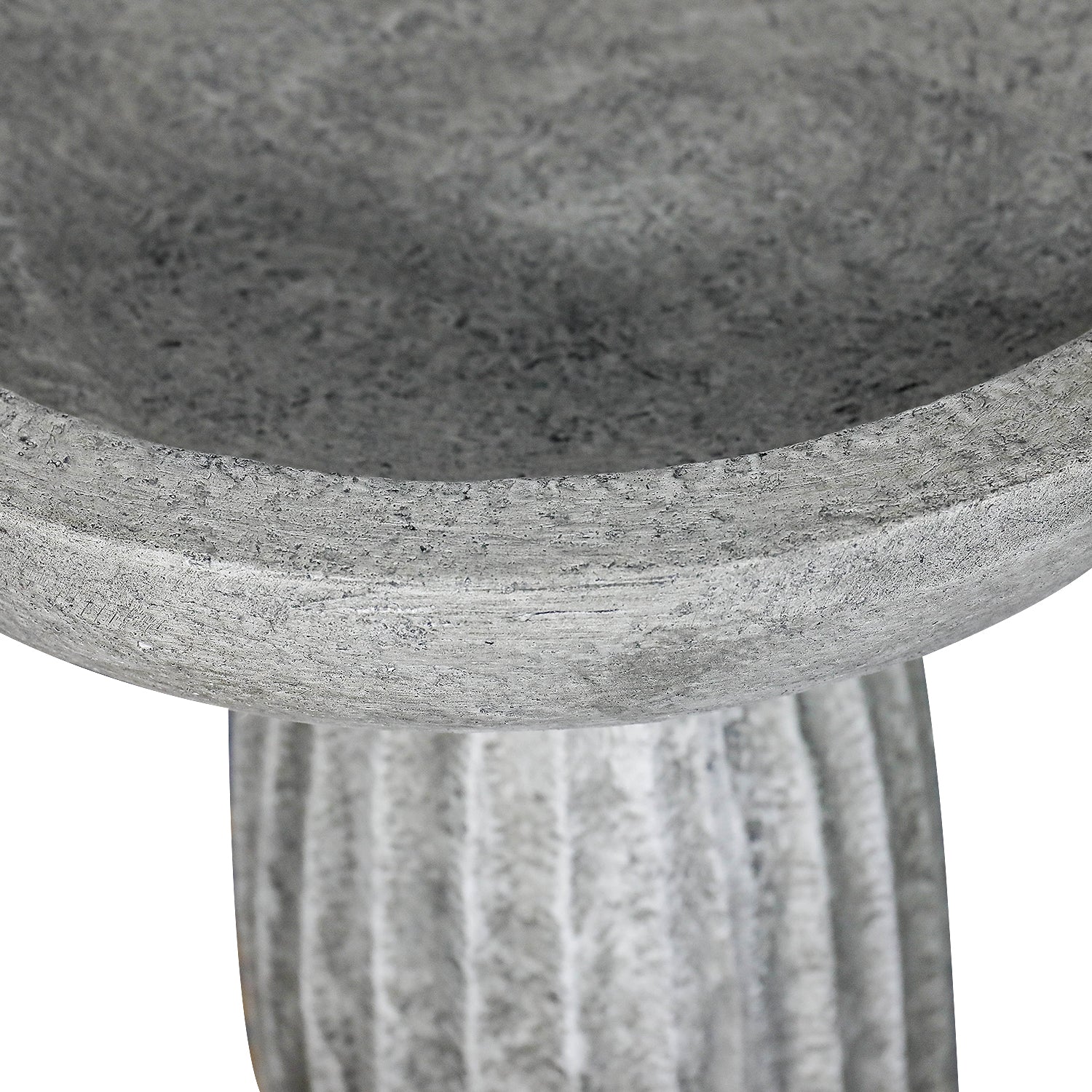 Close-up of shallow concrete bird bath basin rim with natural matte gray finish
