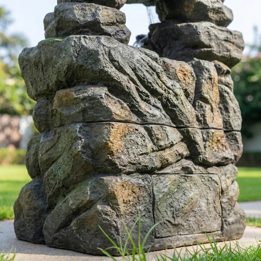 Detailed low-angle view of a premium resin waterfall base with a heavy, realistic rock look.