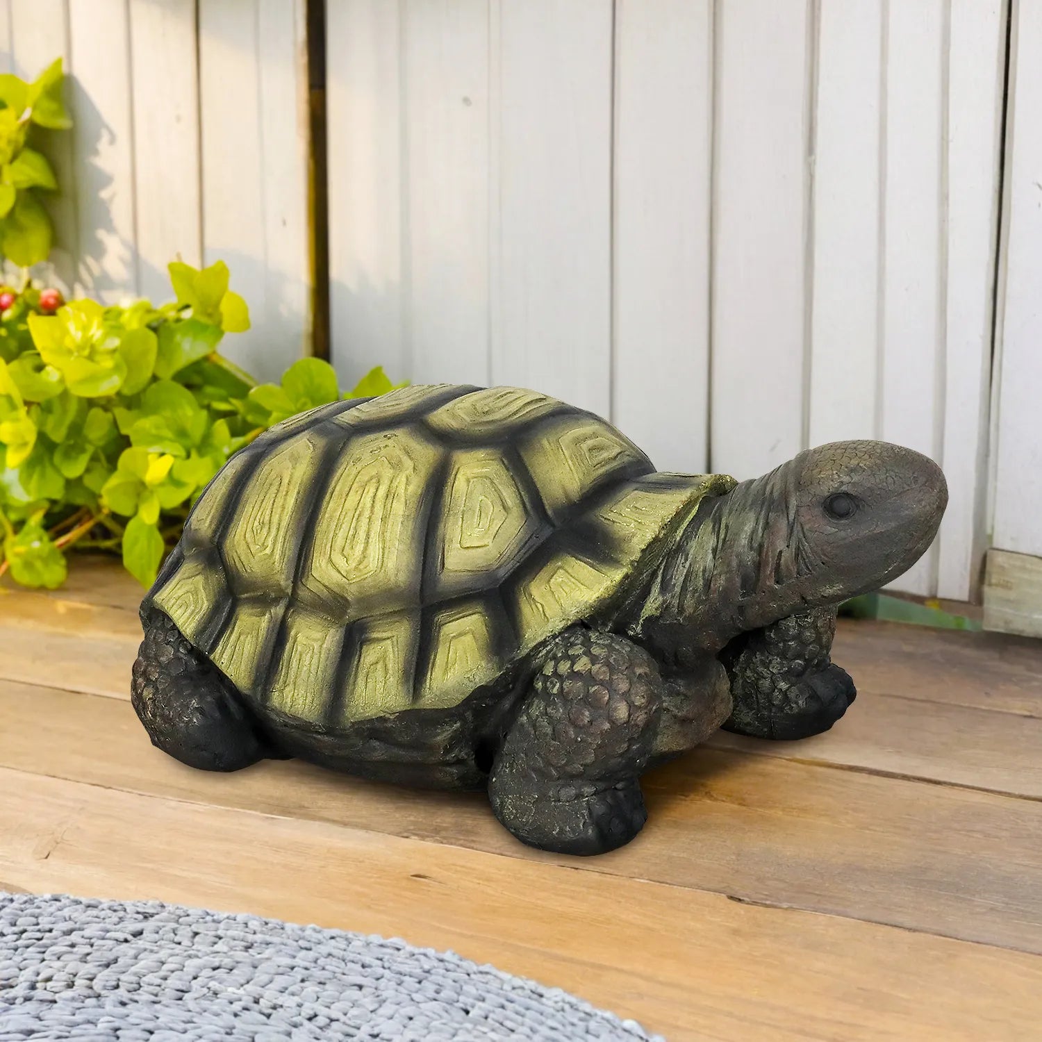 Durable GFRC tortoise statue sitting on a wooden garden deck.