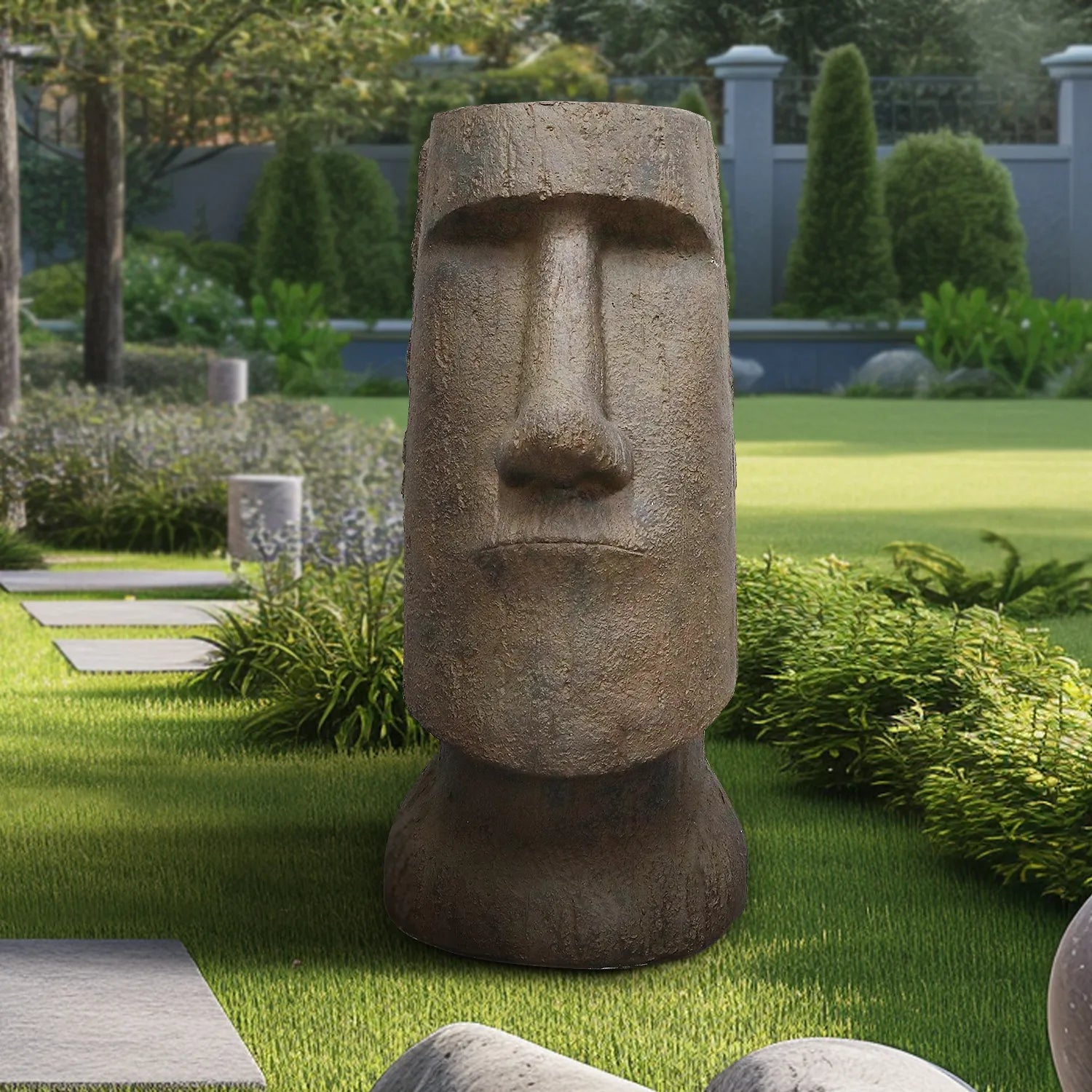Durable concrete Easter Island head statue integrated into a modern landscaped garden pathway.