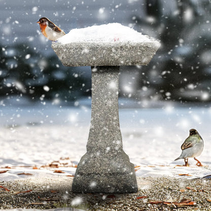 Durable concrete birdbath standing in the snow, demonstrating weather-resistant cast construction.