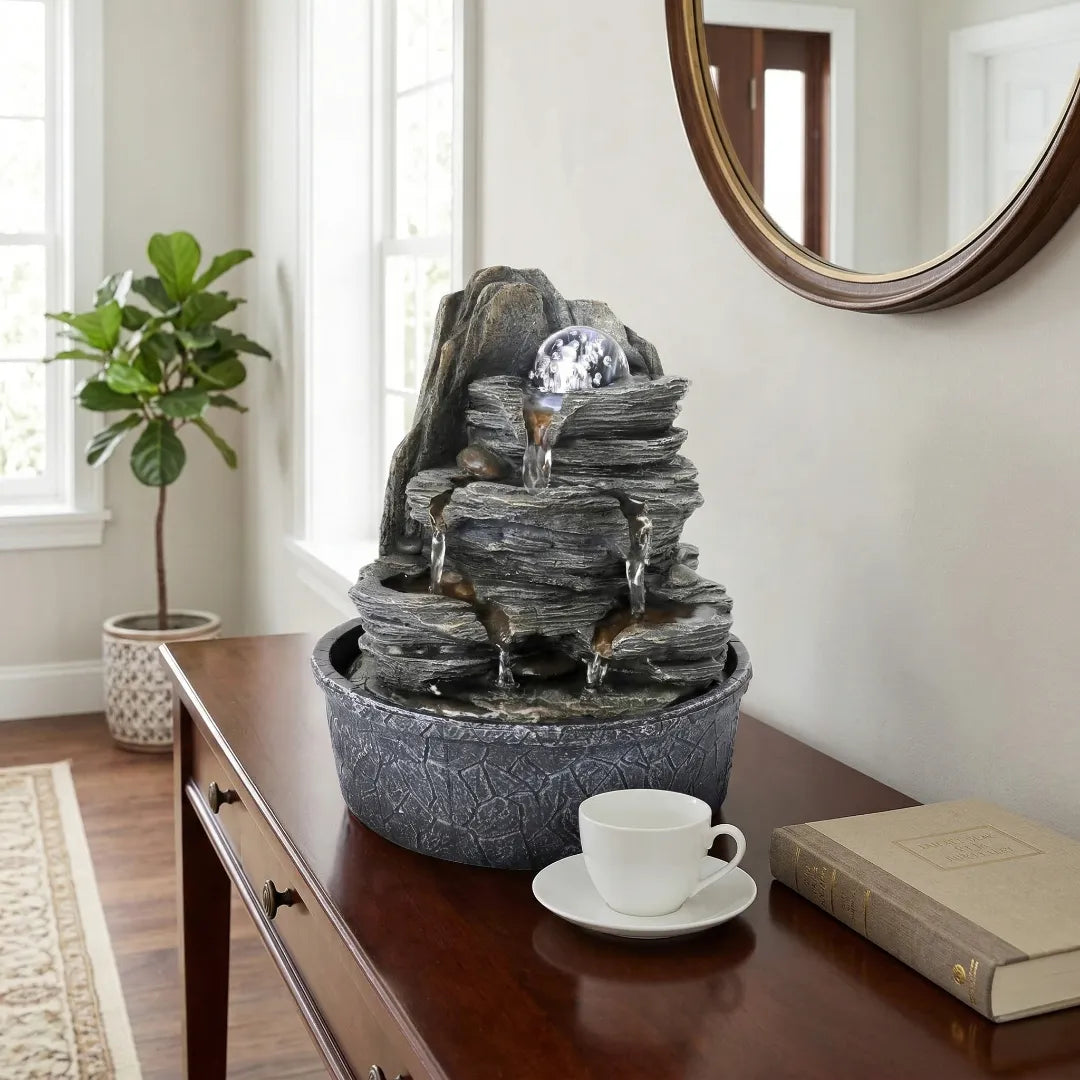 Elegant indoor slate tabletop fountain on a polished wood console table, keeping the surrounding surface completely dry.