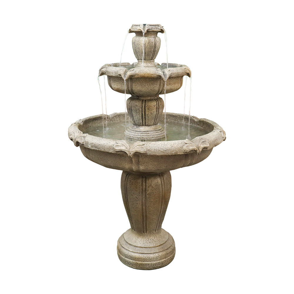 Concrete 3 tier water fountain with fleur de lis relief running in a garden