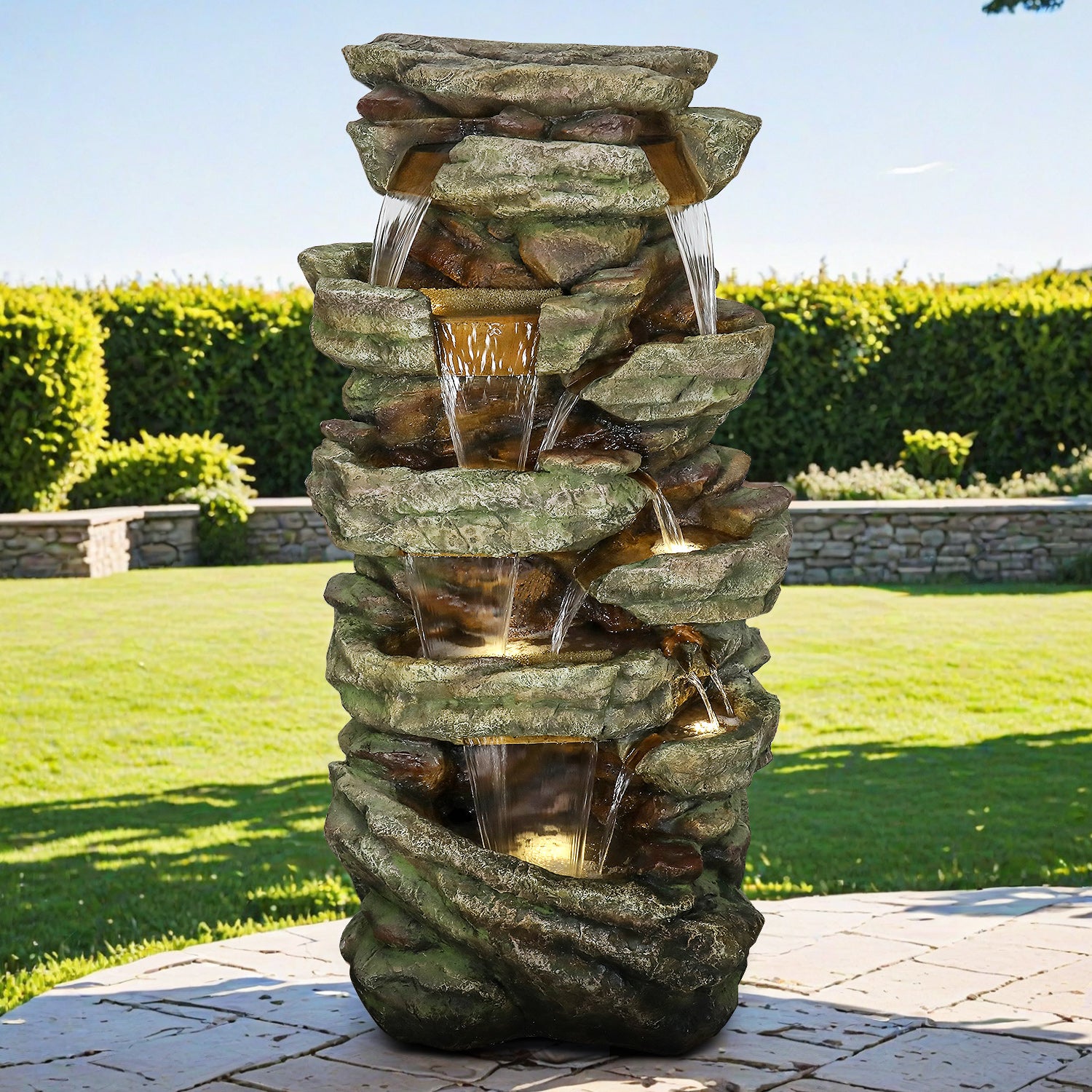 Large 47.2"H cascading rock outdoor fountain acting as a majestic centerpiece in a green garden