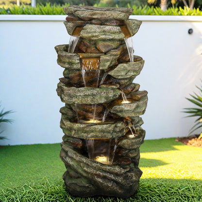 Large 47.2"H cascading rock outdoor waterfall fountain integrated into a green garden lawn.