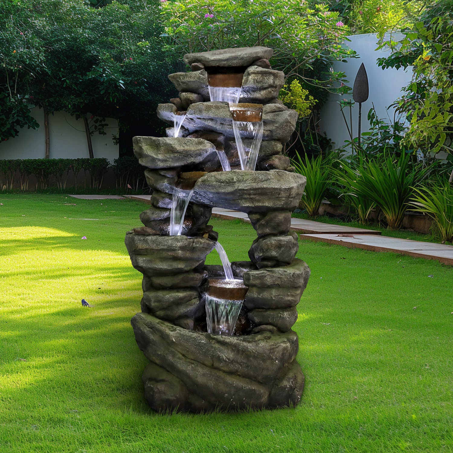 Large 7-tier realistic rock waterfall fountain standing beautifully on a lush green lawn.