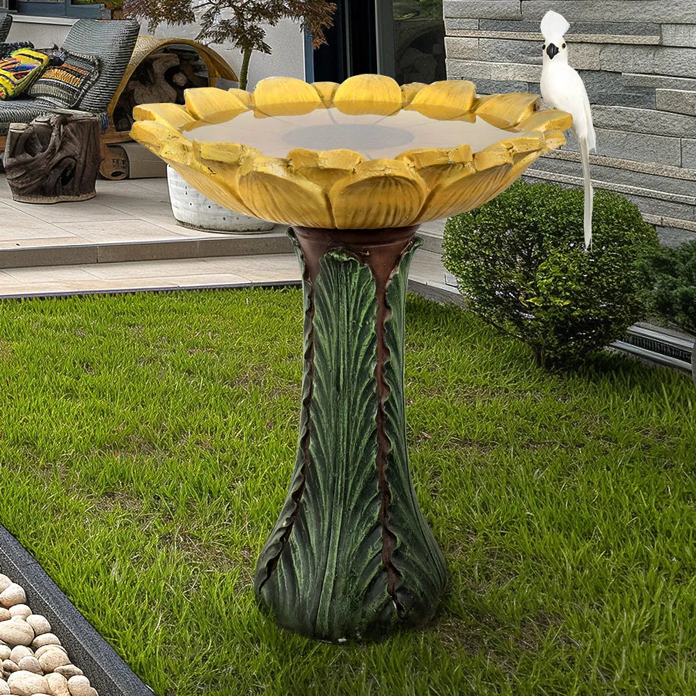 Large sunflower birdbath for outside decor placed on a manicured green lawn.