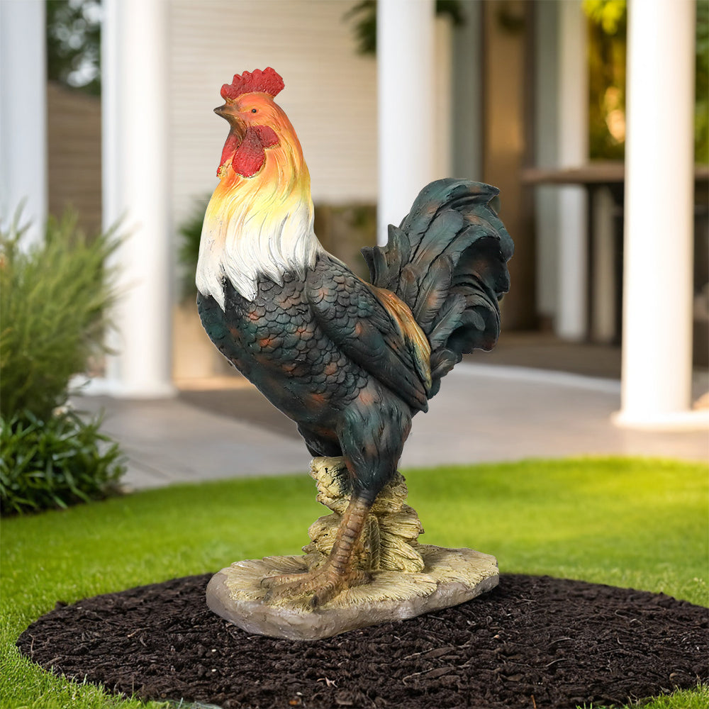 Lifelike rooster garden statue with a red comb and hand-painted feathers in a garden bed.