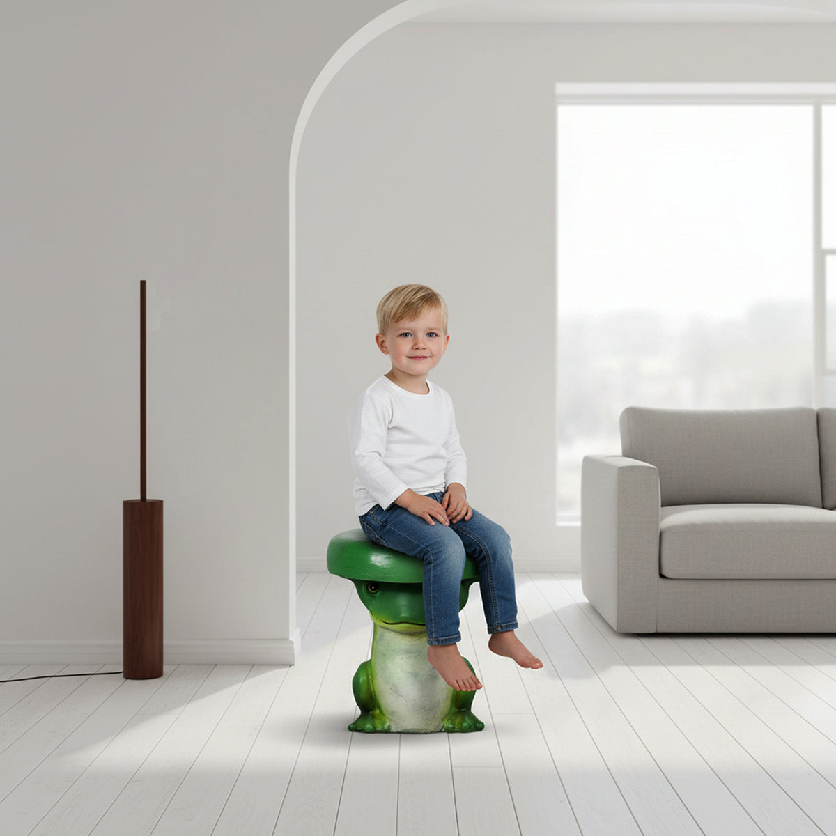 Little boy sitting safely on the cute green frog indoor stool in a bright, minimalist living room.