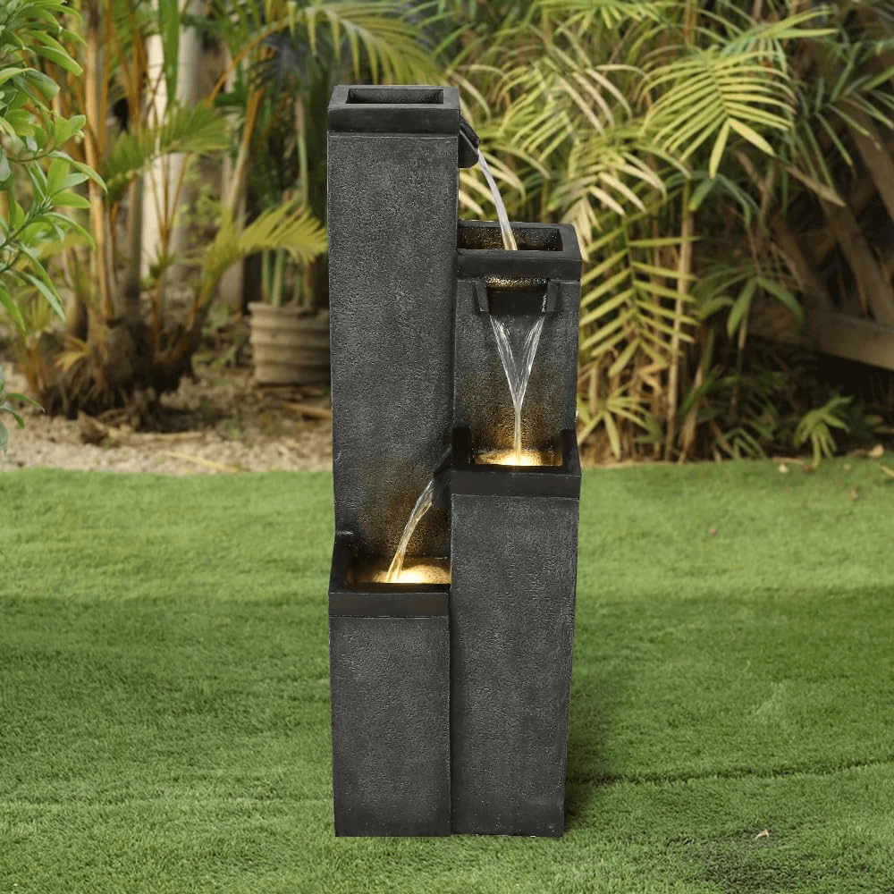 Minimalist cement finish water feature standing elegantly on a fresh green lawn