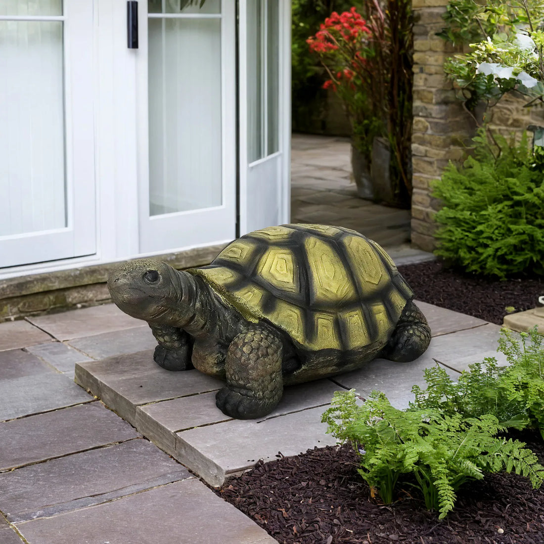 Realistic concrete turtle garden figurine placed as a welcome statue at a modern home entryway.