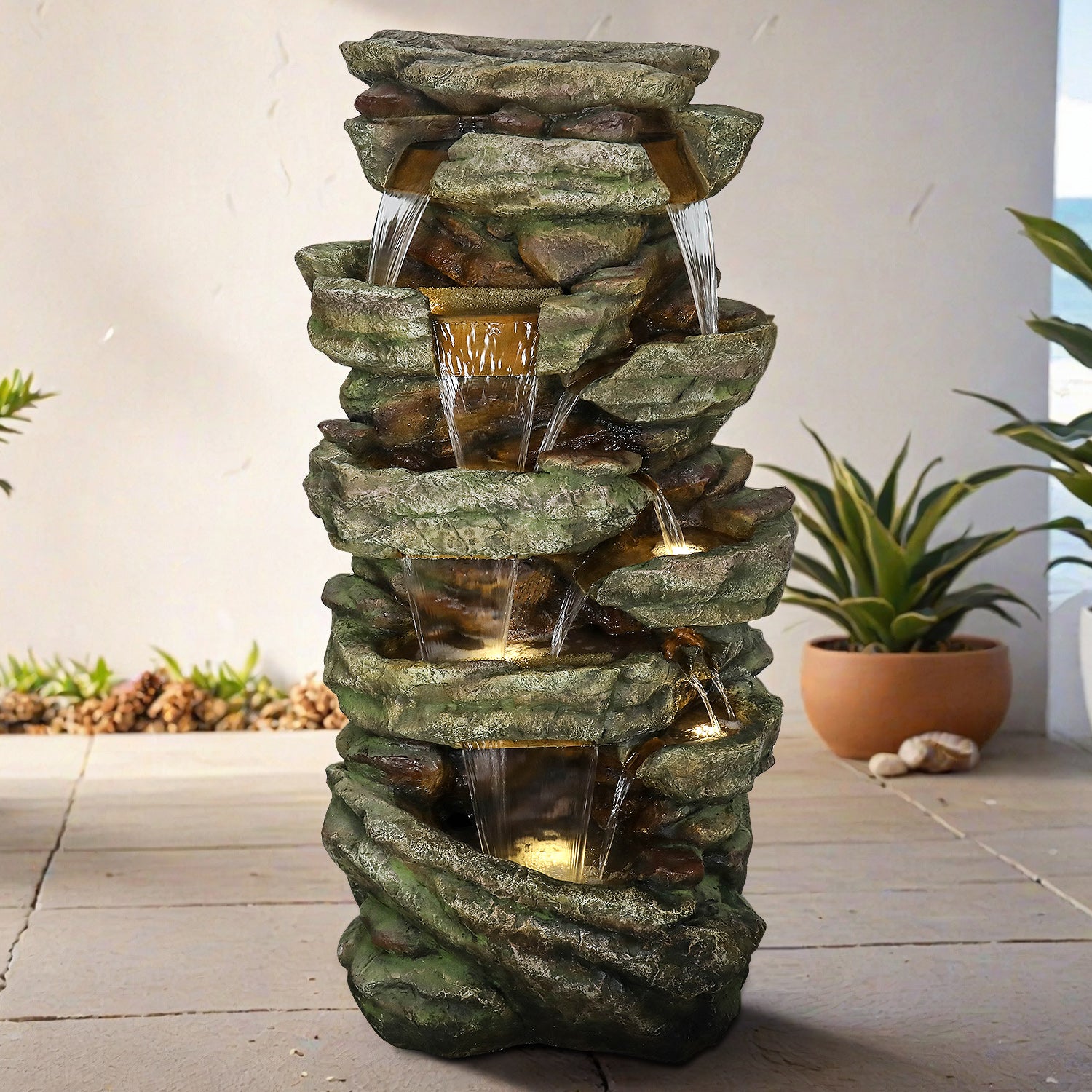 Realistic poly-resin faux stone waterfall fountain decorating a spacious outdoor patio deck