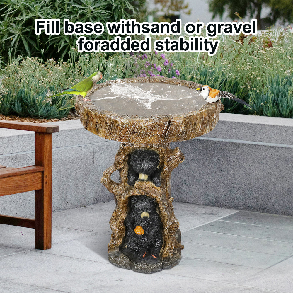 Rustic bear bird bath placed on a gravel patio