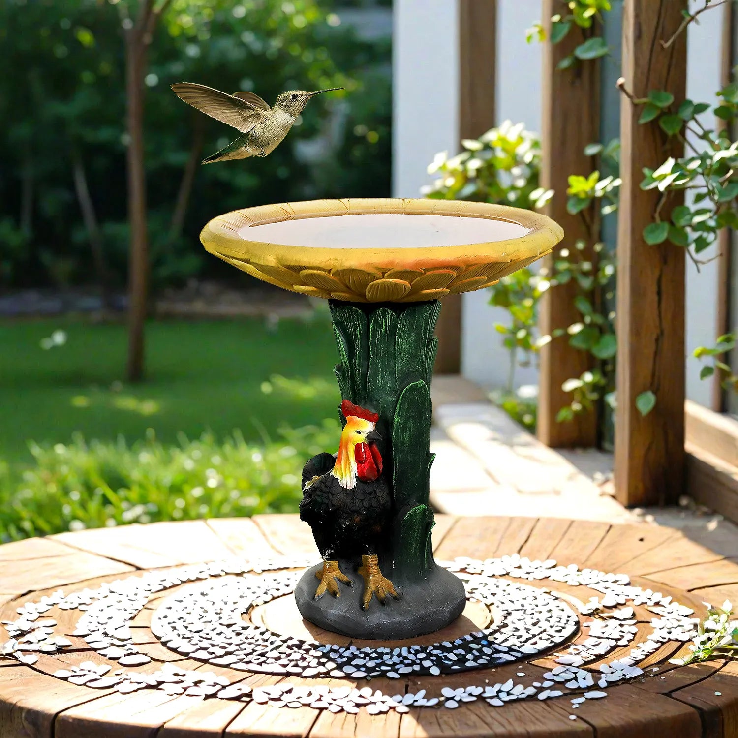 Sunflower birdbath with rooster statue and leaf pedestal on a circular garden patio.