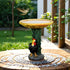 Sunflower birdbath with rooster statue and leaf pedestal on a circular garden patio.