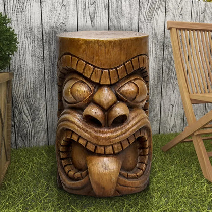 Tiki God Kanaloa end table used as a garden stool in a tropical outdoor patio setting.