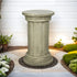 Timeless column-inspired concrete side table placed on a patio against a clean white wall.