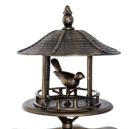birdhouse canopy and water basin close up on bronze verdigris bird bath in warm garden light