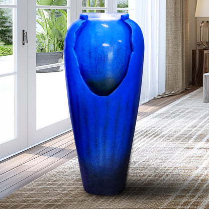 blue concrete jar fountain positioned next to a garden gate