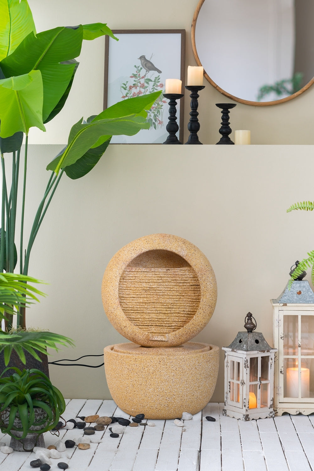 Cream concrete ring fountain in a lifestyle corner setting with plants and lanterns