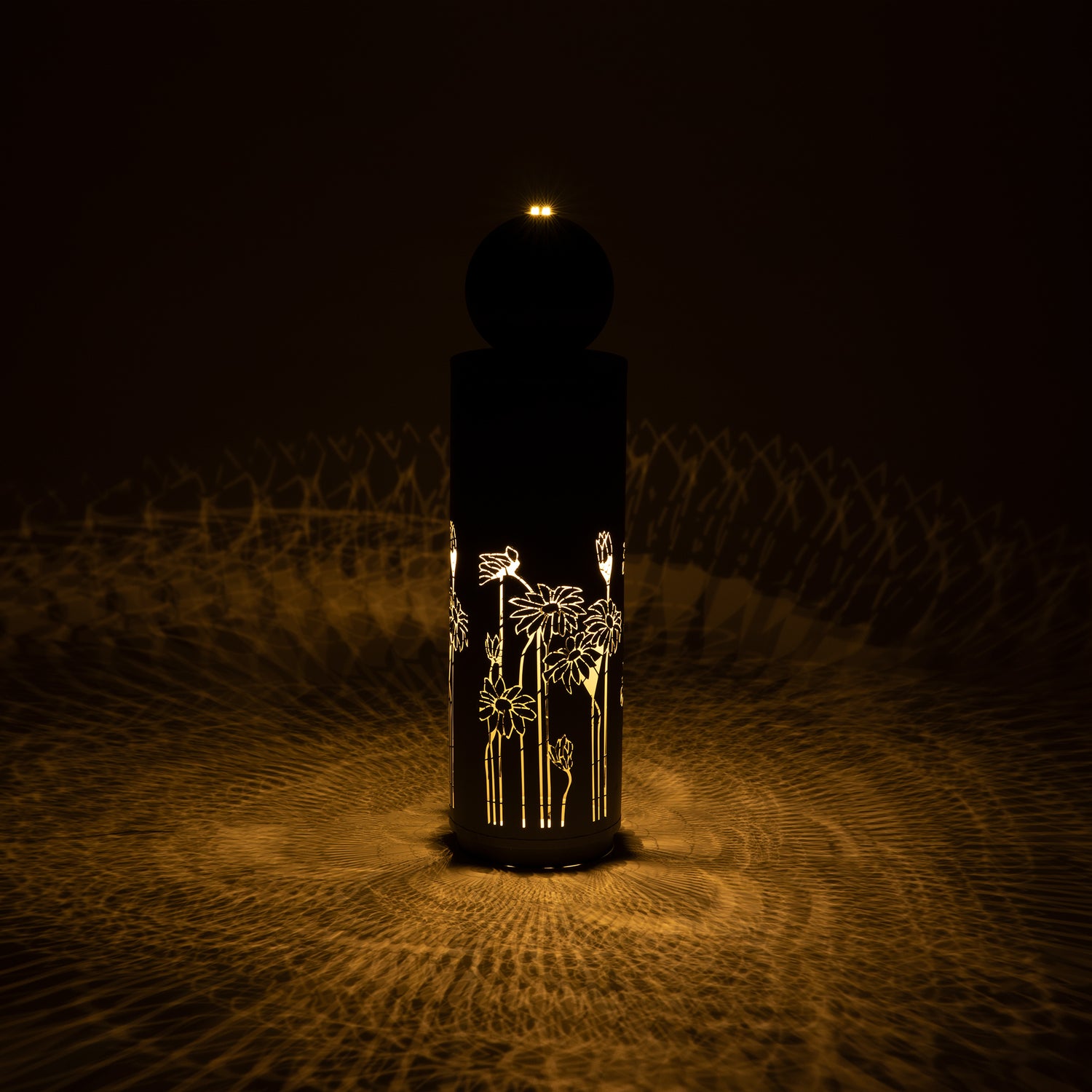 gilded vine cutout fountain glowing at night with illuminated pattern